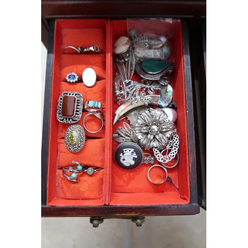 174 - A jewellery cabinet of eight drawers containing various silver and costume jewellery - items include... 