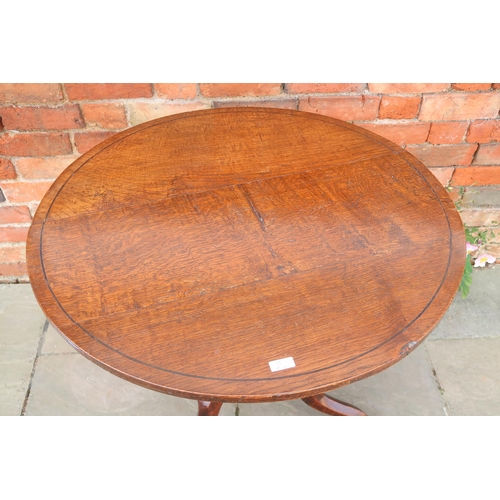 713 - A Georgian oak circular tilt top tripod table raised on pad feet, 80cm x 74cm high