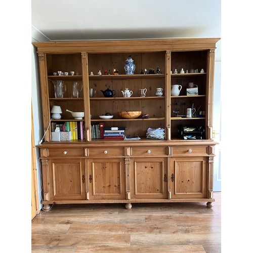 711 - A large pine dresser open plate rack with four shelves over base of four drawers above four doors ra... 