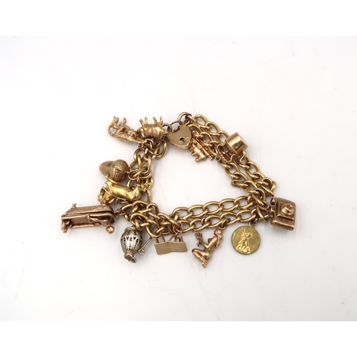  A 9ct Marked Yellow gold charm bracelet with eleven charms. 55 Grams.