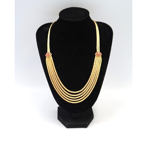  A five row articulated textured necklet with two ruby clusters. Stamped 750. Weight 52.29 grams