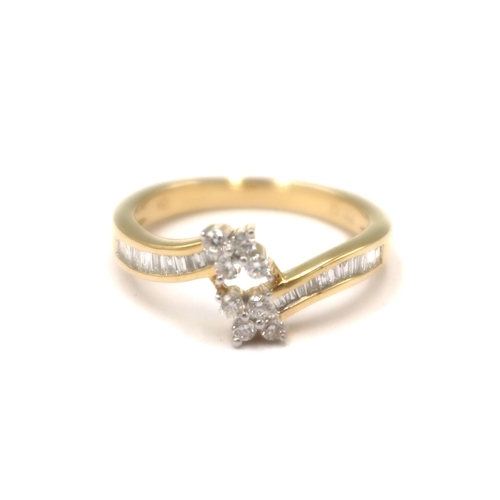 111 - An 18ct gold crossover ring with baguette cut diamond shoulders and brilliant cut diamond cluster te... 