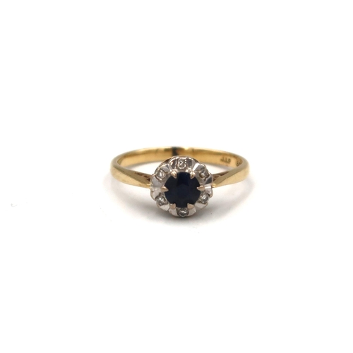 12 - A sapphire and diamond daisy cluster ring. Size L. Stamped 18K. Weight 3.09 grams