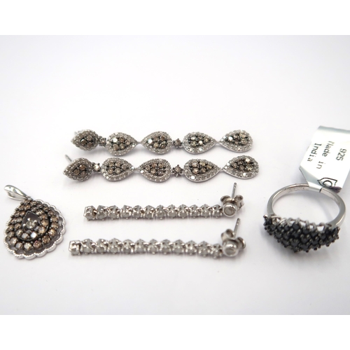 130 - Four pieces of silver and diamond jewellery. To include a black diamond cluster ring. Size M. Stated... 