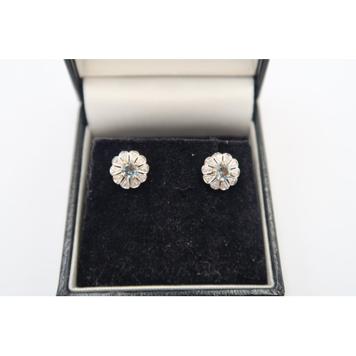 137 - A pair of 9ct yellow and white gold aquamarine and diamond flower head earrings - approx 8mm diamete... 