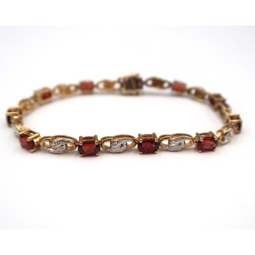 165 - A 9ct gold oval garnet panel bracelet with bicolour spacer panels each set with two single cut diamo... 