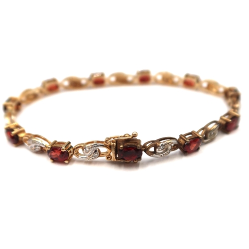 165 - A 9ct gold oval garnet panel bracelet with bicolour spacer panels each set with two single cut diamo... 