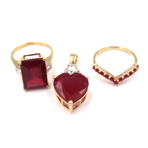 174 - Three pieces of 9ct gold ruby jewellery. To include an eleven stone wishbone ring. Size M. A heart s... 