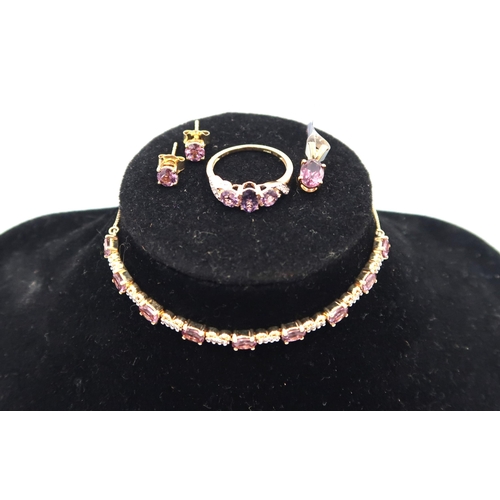 182 - Four pieces of 9ct gold purple spinel jewellery. To include an oval single stone pendant. A pair of ... 