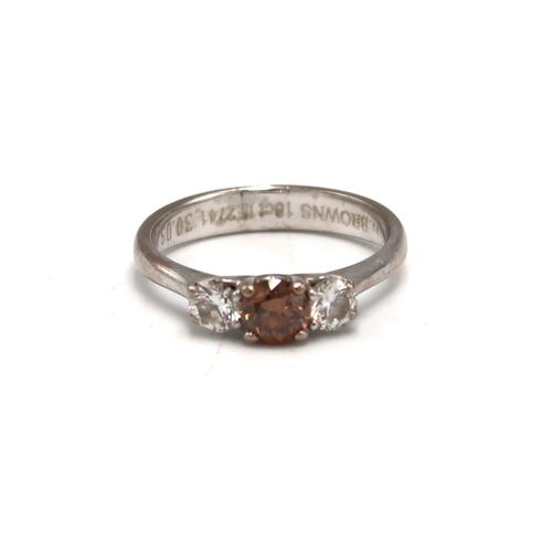 212 - An 18ct white gold and diamond three stone ring, the central fancy cognac coloured stone of approxim... 