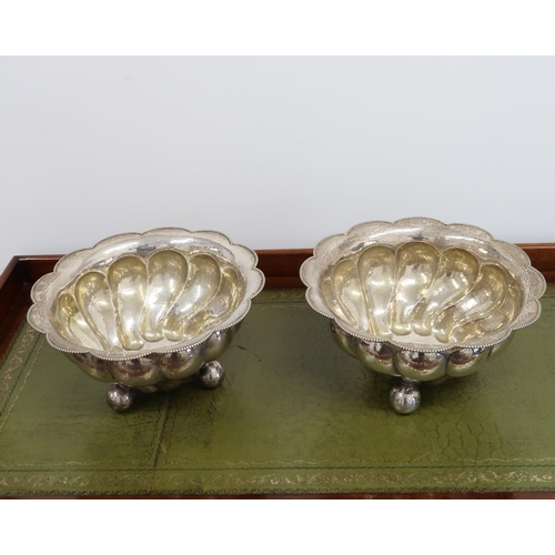 333 - A pair of .800 Continental silver, lobbed bowls with planished finish, beaded rims and standing on t... 