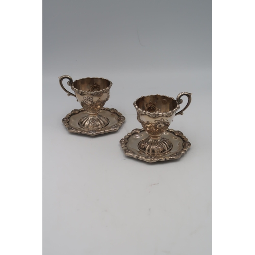 342 - A pair of Austrian silver cups, single handle decorated with floral sprays on trays, approx 10.7 tro... 