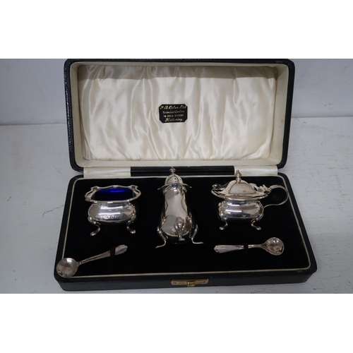 345 - A silver condiment set, complete with blue glass liners, with original box.