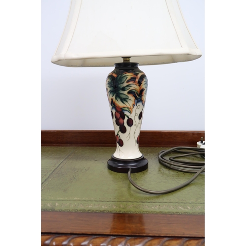 481 - A 20th century Moorcroft table/side table lamp with grape and vine detail 30cm high.