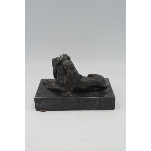 483 - A Bronze of a recumbent Lion set on marble base.