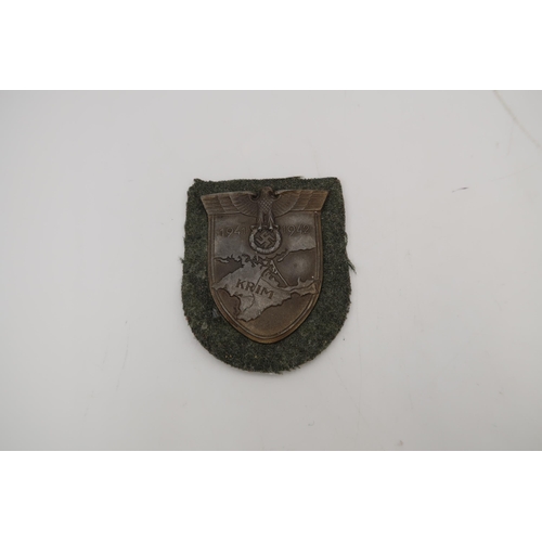 547A - A Third Reich Krim Campaign shield, retaining the backing fabric, this example is complete but shows... 