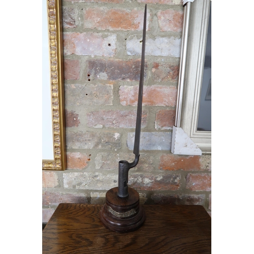 551A - A Waterloo relic Brown Bess socket bayonet, mounted on a turned wood display plinth, this socket bay... 