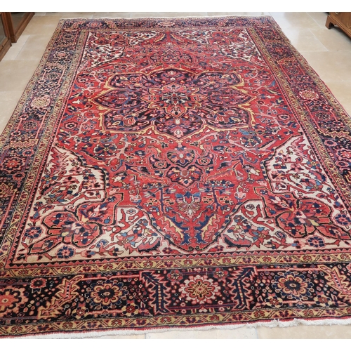 571 - A large Persian handmade rug with a red field, 370 by 250cm.