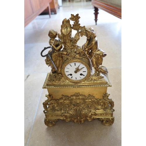 619 - A French gilt bronze mantle clock, modelled with a courting couple above, 45cm high.