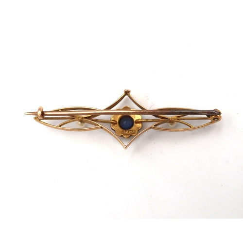 84 - A 15ct marked yellow gold bar brooch, with central flowerhead setting, with blue stone surrounded by... 