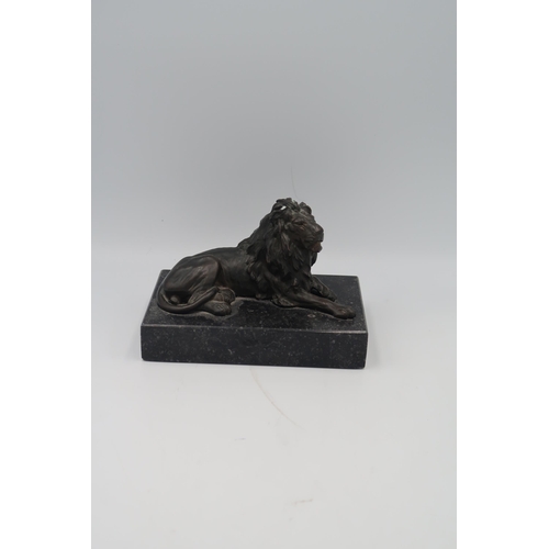 438 - A Bronze of a recumbent Lion set on marble base.