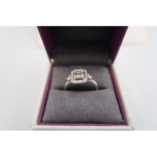 12 - An 18ct white gold baguette and brilliant cut diamond cluster ring - stated total diamond weight 0.4... 