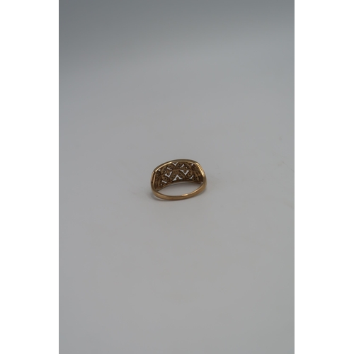 131 - A marked .375 yellow gold dress ring pierced shoulder with small diamonds. Size T. 3.6grams.