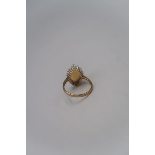 143 - A marked .375 yellow gold dress ring with Marquise cut Citrine surrounded by twenty for small round ... 