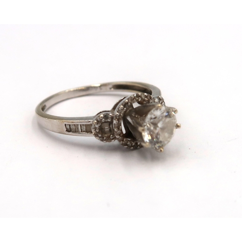 163 - A 14ct white gold diamond solitaire ring - The round brilliant cut diamond surrounded with round and... 