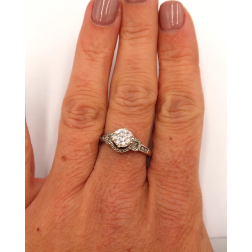 163 - A 14ct white gold diamond solitaire ring - The round brilliant cut diamond surrounded with round and... 