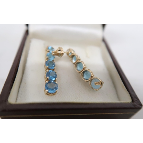 30 - A pair of 14ct gold and topaz drop earrings, each set with five graduated topaz, the smallest approx... 