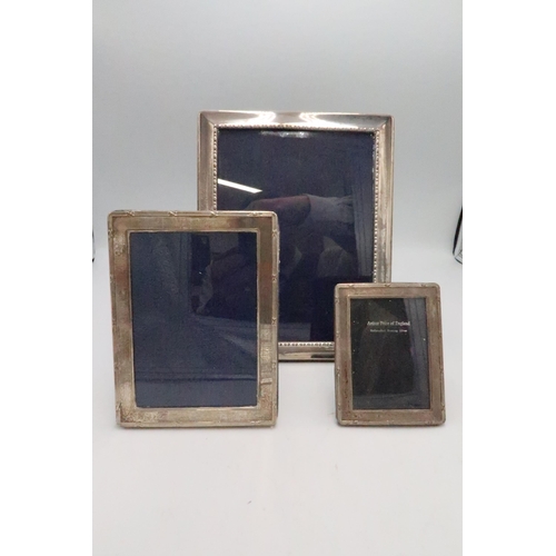 352 - A group of three silver picture frames, each of rectangular form with velvet backed stands, largest ... 