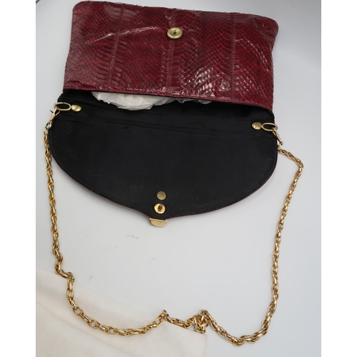 451 - A Jane Shilton burgundy snakeskin hand bag, of clutch foldover form, 29 by 16cm, complete with cloth... 