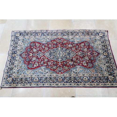 571 - A Persian woollen rug of geometric pattern to central red field - 245cm x 136cm