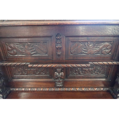 678 - A carved side table, a 1930's heavily carved oak side cabinet, 115cm wide x 140cm tall