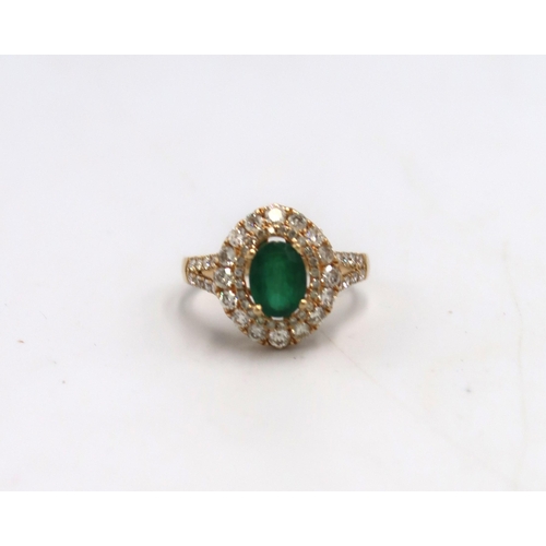 An 18ct Yellow Gold dress ring with oval cut Emerald 1.5ct, surrounded by a double halo of Diamonds 1.1ct - approx weight 5.7grams - ring Size P