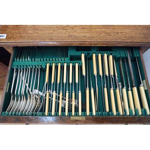 691 - A 1930's oak two drawer cutlery table with assorted Walker & Hall cutlery