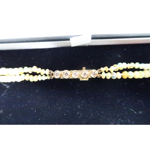 17 - An opal beaded double strand necklace, with 18ct gold and diamond five stone clasp, total length 45c... 