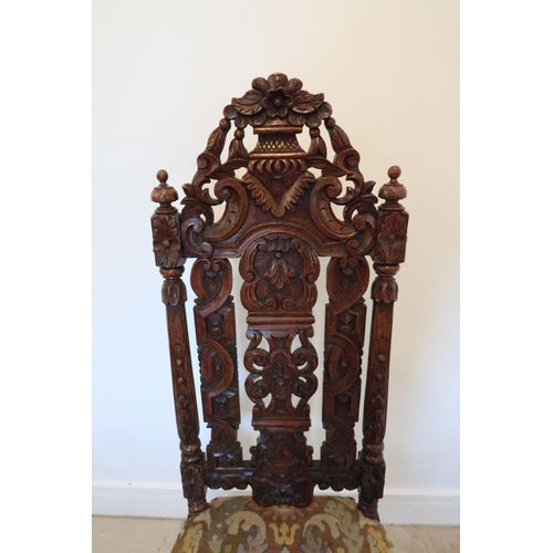 643 - A carved oak Carolean style hall chair, profusely carved with overstuffed seat raised on turned and ... 