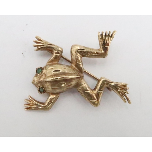 79 - A 9ct gold frog brooch with emerald eyes. Length 40mm. Weight 5.45 grams.