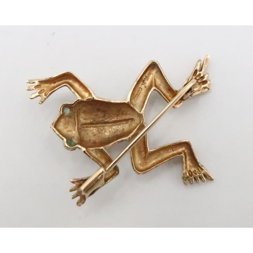 79 - A 9ct gold frog brooch with emerald eyes. Length 40mm. Weight 5.45 grams.