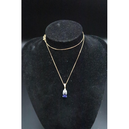 143 - A 9ct gold oval sapphire and trefoil single cut diamond pendant. Weight 2.48 grams