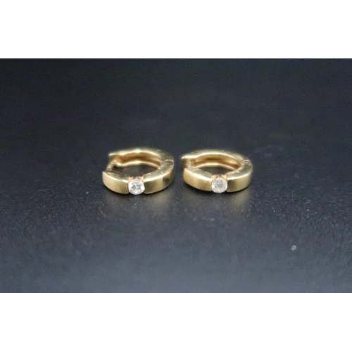 151 - A pair of ear cuffs each set with a brilliant cut diamond. Stamped 750. Weight 4.66 grams. Estimated... 