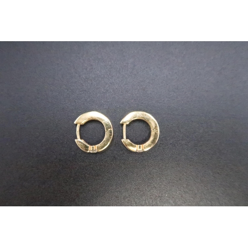 151 - A pair of ear cuffs each set with a brilliant cut diamond. Stamped 750. Weight 4.66 grams. Estimated... 