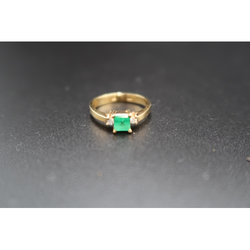 152 - An emerald and diamond three stone ring. The emerald approximately 4.7 by 4.8mm. With a brilliant cu... 