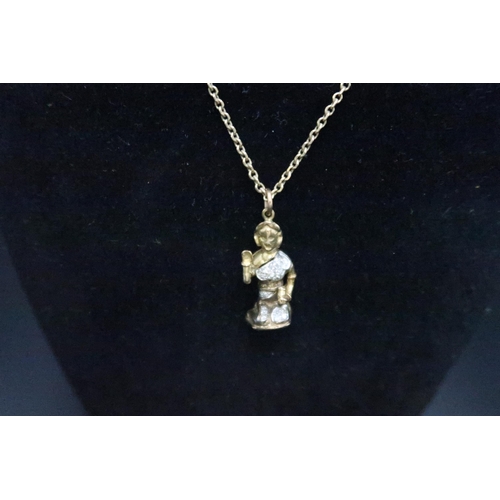 170 - A pave set diamond charm of a figure raising their arm, tests gold 9ct. Suspended from a belcher lin... 