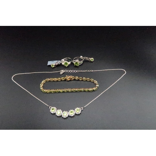 193 - A group of silver and peridot jewellery. To include a bracelet, a necklet, a pair of earrings and tw... 