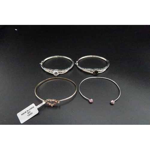 196 - A group of four silver bangles, set with quartz, topaz, zircon, ruby and diamond. Weight 40.41 grams... 