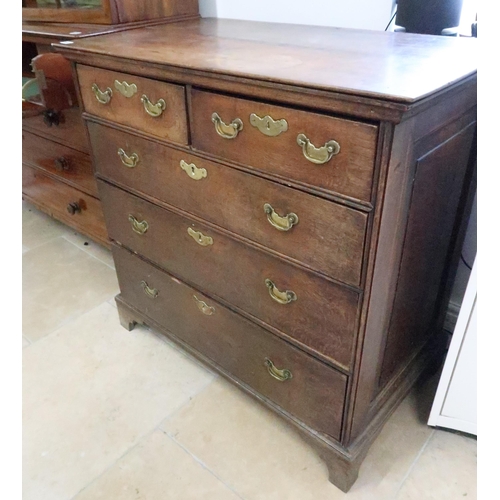 585 - An 18th century elm chest of drawers with brass handles on bracket feet and with oak lined drawers -... 