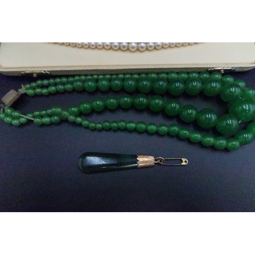 235 - A Jade pendant, a double string of green glass beads along with a string of simulated pearls and ear... 